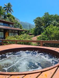 a hot tub on a deck with a view of the mountains at Pousada Rubi in Abraão