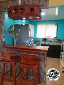 a kitchen with a wooden bar with stools at Black Snapper House in Golfito