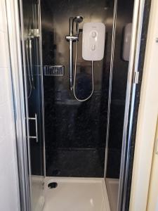 a shower with a glass door in a bathroom at The Penkelie in Southport
