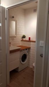 a bathroom with a washing machine and a sink at Apartament Verona in Lublin