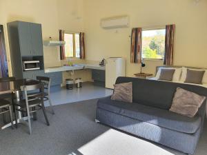 a living room with a couch and a kitchen at Hanmer Springs Forest Camp Trust in Hanmer Springs