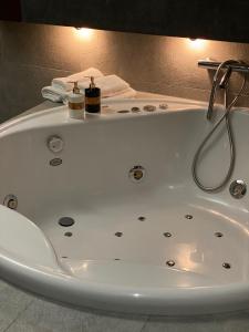 W łazience znajduje się biała wanna i umywalka. w obiekcie Family & Business Sauna Apartments Klonowa nad Zalewem, Unikat SPA - 2 Bedroom with Private Sauna, Jacuzzi, Air Conditioning, Garage - The Highest Standard! w Kielcach