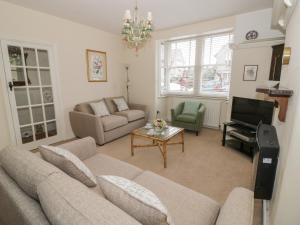 a living room with a couch and a piano at 5 Albany Road in Stratford-upon-Avon