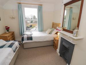 a bedroom with two beds and a mirror and a fireplace at 5 Albany Road in Stratford-upon-Avon