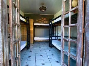 a room with two bunk beds and a tiled floor at A Coroa Hostel & Suites in Arraial do Cabo