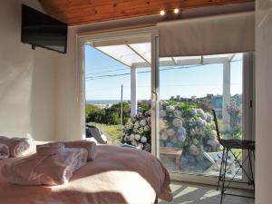 a bedroom with a view of a large window at Kanaloah Lodge & Cabins in Punta Del Diablo +23 photos