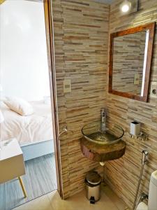 a bathroom with a sink in a room with a bed at Kanaloah Lodge & Cabins in Punta Del Diablo