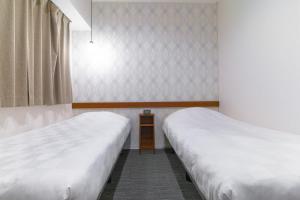 a room with two beds and a window at Meldia Stay Omiya KARIGANE in Kyoto