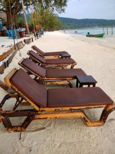 a group of lounge chairs on a beach at Sweet Time Bungalows in Koh Rong Sanloem