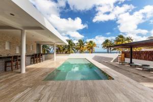 BEACHFRONT COCO Modern Designer House by PENINSULA STAYS في San Crisanto: مسبح لا نهاية له على سطح الفيلا