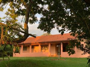 a house with an orange roof and a yard at Chácara Santo Antonio in Brotas