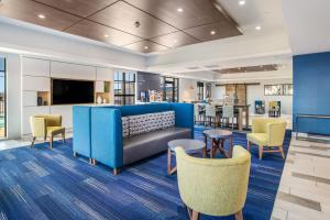 eine Lobby mit einem blauen Sofa und Stühlen in der Unterkunft Holiday Inn Express & Suites Tulsa East - Catoosa, an IHG Hotel in Catoosa