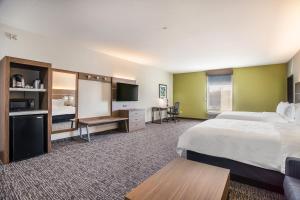 a hotel room with a bed and a flat screen tv at Holiday Inn Express & Suites Tulsa East - Catoosa by IHG in Catoosa +57 photos