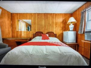 a bedroom with a bed with a red pillow on it at Monmouth OYO in Neptune City +4 photos