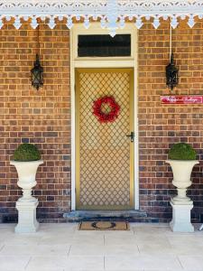 a door with a wreath on it on a brick building at Woodstock Cottage in Temora