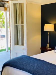 a bedroom with a bed and a white door at Woodstock Cottage in Temora