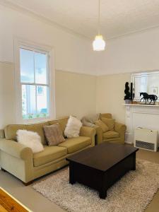 a living room with a couch and a coffee table at Woodstock Cottage in Temora