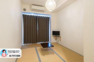 大阪市にあるTabist グローレ大阪の窓、椅子、テレビが備わる客室です。