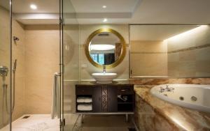 a bathroom with a sink and a tub and a mirror at Taipei Lotty Hotel in Taipei