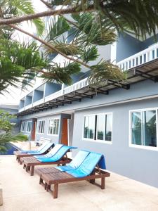 a row of lounge chairs in front of a building at AM Surin Place - SHA Extra Plus in Surin Beach