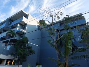 un bâtiment bleu avec des arbres devant lui dans l'établissement AM Surin Place - SHA Extra Plus, à Surin Beach