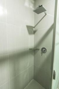 a shower stall with a glass door with a shower at Nakua Paracas Lodge in Paracas