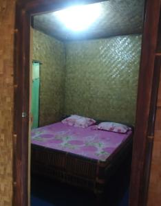 a bedroom with a bed with purple sheets and a mirror at De Salak Homestay in Bogor