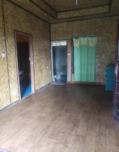 een grote lege kamer met een houten vloer bij De Salak Homestay in Bogor