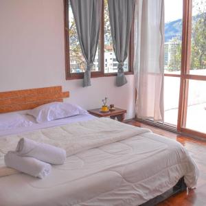 a white bed in a bedroom with a large window at Play House in Quito