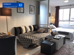 un soggiorno con un divano e un letto di Stay in Style at Oasis a Chiang Mai