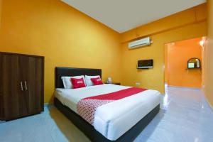 En eller flere senge i et værelse på Super OYO 90039 Coop Hotel Kangar