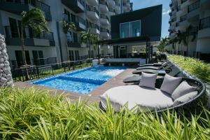 a hotel with a pool and lounge chairs next to a building at Mantra Beach Condominium Suite - Mae Phim in Ban Tha Fat