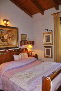 a bedroom with a large bed and a painting on the wall at La Corte del Macero in Castelfranco Emilia