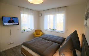 a bedroom with a bed and a flat screen tv at 2 Bedroom Cozy Apartment In Rechlin in Rechlin