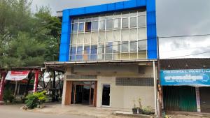 ein blau-weißes Gebäude an der Straßenseite in der Unterkunft De' Premium Hotel Musi Raya in Sukarami