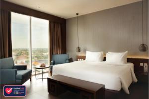 Uma cama ou camas num quarto em The Luxton Cirebon Hotel and Convention
