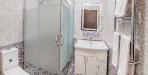 y baño con lavabo y ducha acristalada. en Usman, en Samarkand