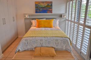 a small bedroom with a bed with a wooden bench at Concord Modern Apartment in Stellenbosch in Stellenbosch