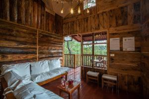 ein Wohnzimmer mit einem Sofa in einem Blockhaus in der Unterkunft Villa Verde in Perquín