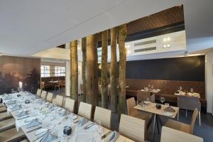 Badischer Hof في بوهل: غرفة طعام مع طاولة طويلة مع أطباق بيضاء