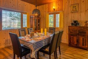 ナイニタールにあるVilla Clouds Haven by VEO - Part of StayVistaの部屋の中にテーブルと椅子があるダイニングルーム