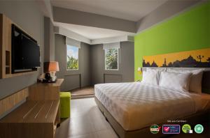 ジョグジャカルタにあるKHAS Malioboro Hotelのベッド1台、薄型テレビが備わるホテルルームです。