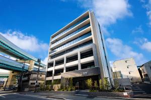 a tall building in a city with a sky at Tomariehotel & condominium in Fukuoka