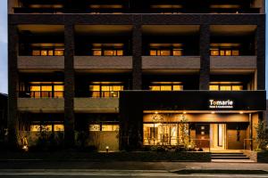 a lit up building with a sign in front of it at Tomariehotel & condominium in Fukuoka