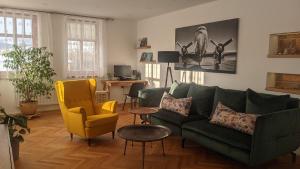 salon z zieloną kanapą i żółtym krzesłem w obiekcie Apartman692 w Vrchlabi