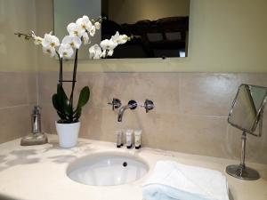 a white sink sitting under a mirror in a bathroom at One Holyrood Hotel & Cafe in Newport