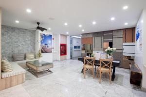 cocina y sala de estar con mesa y sillas en Costa Beach Residence & Jacuzzi, en Sattahip