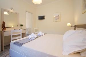 a bedroom with a large white bed and a desk at Prince Studios in Sami