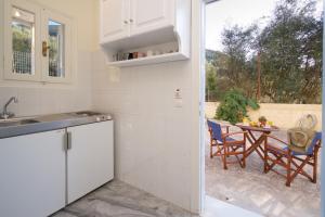 a kitchen with a sink and a table with chairs at Prince Studios in Sami
