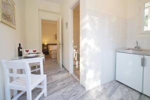 a kitchen with a white table and a white chair at Prince Studios in Sami